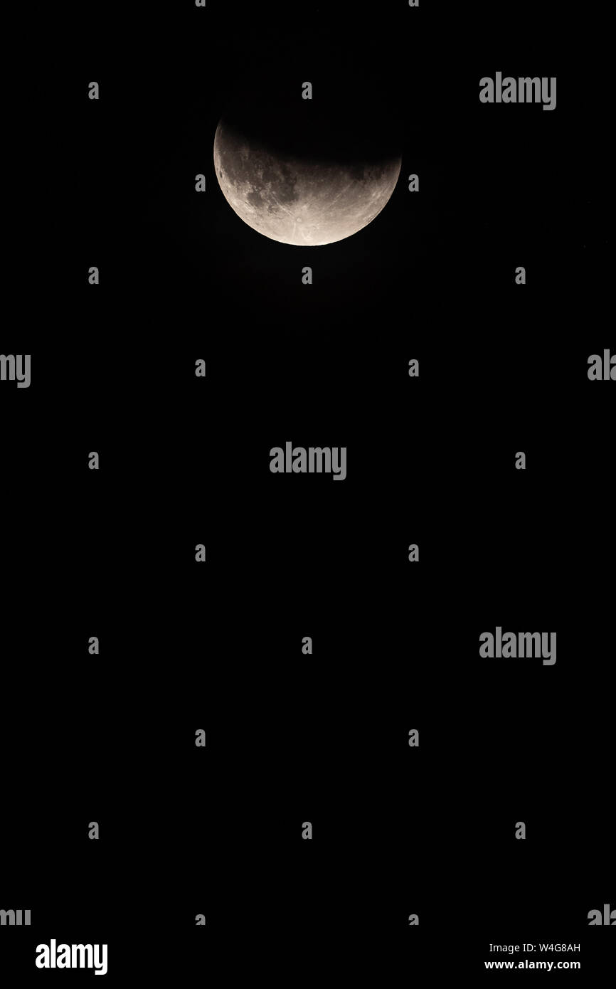 Mond in Lunar Eclipse mit der unteren Hälfte des Mondes im oberen Drittel der Rahmen sichtbar. Nach oben Teil des Mondes im Schatten. Stockfoto