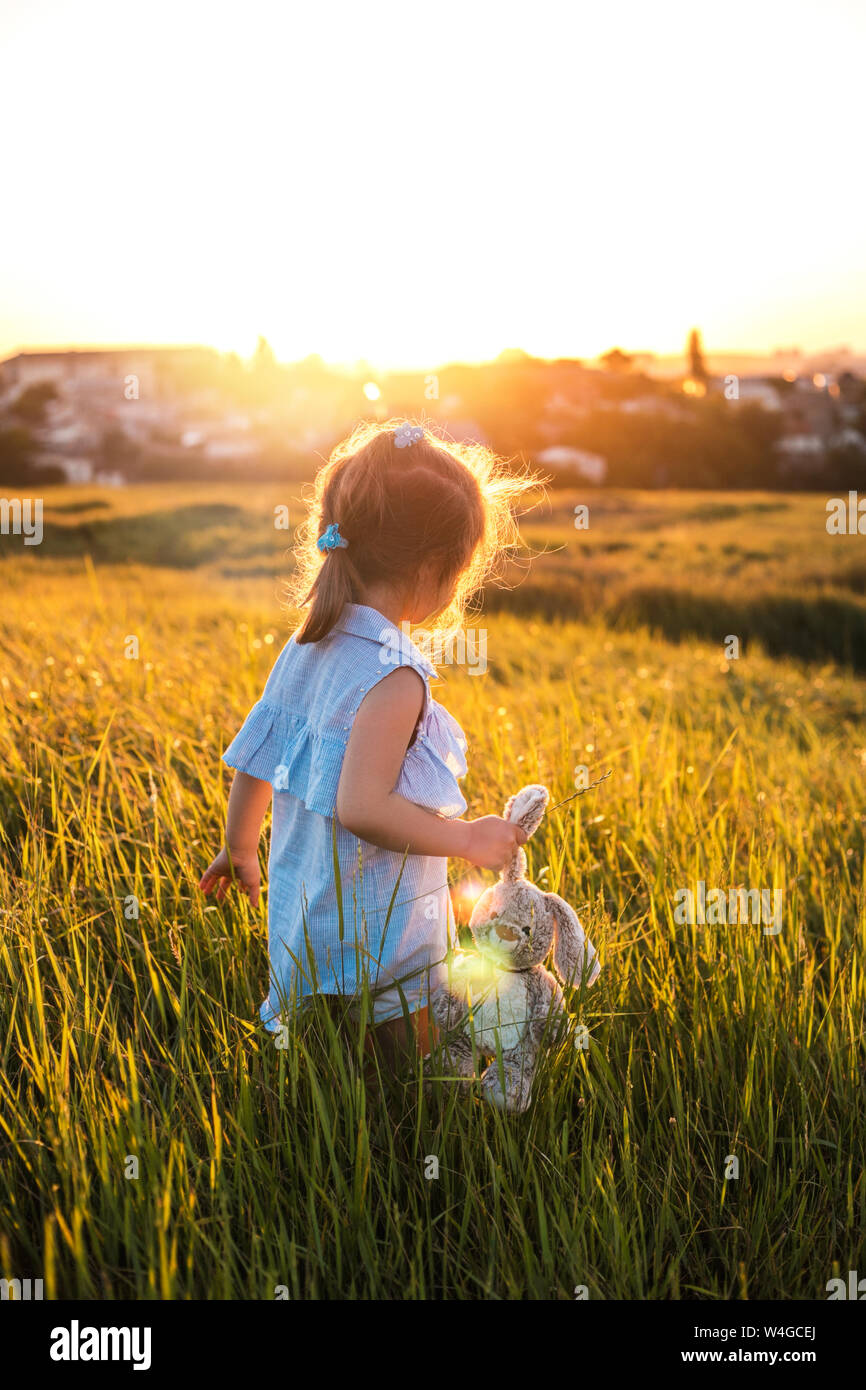 Glückliche kleine Mädchen im Sommer Feld bei Sonnenuntergang ...