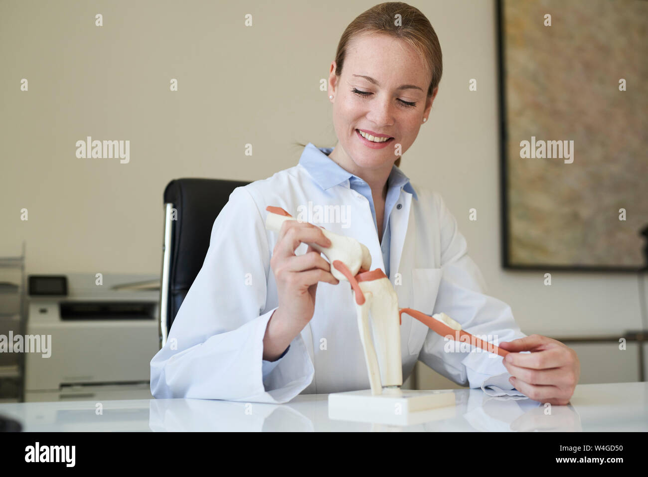 Frau Doktor mit kniegelenk Modell in der medizinischen Praxis Stockfoto