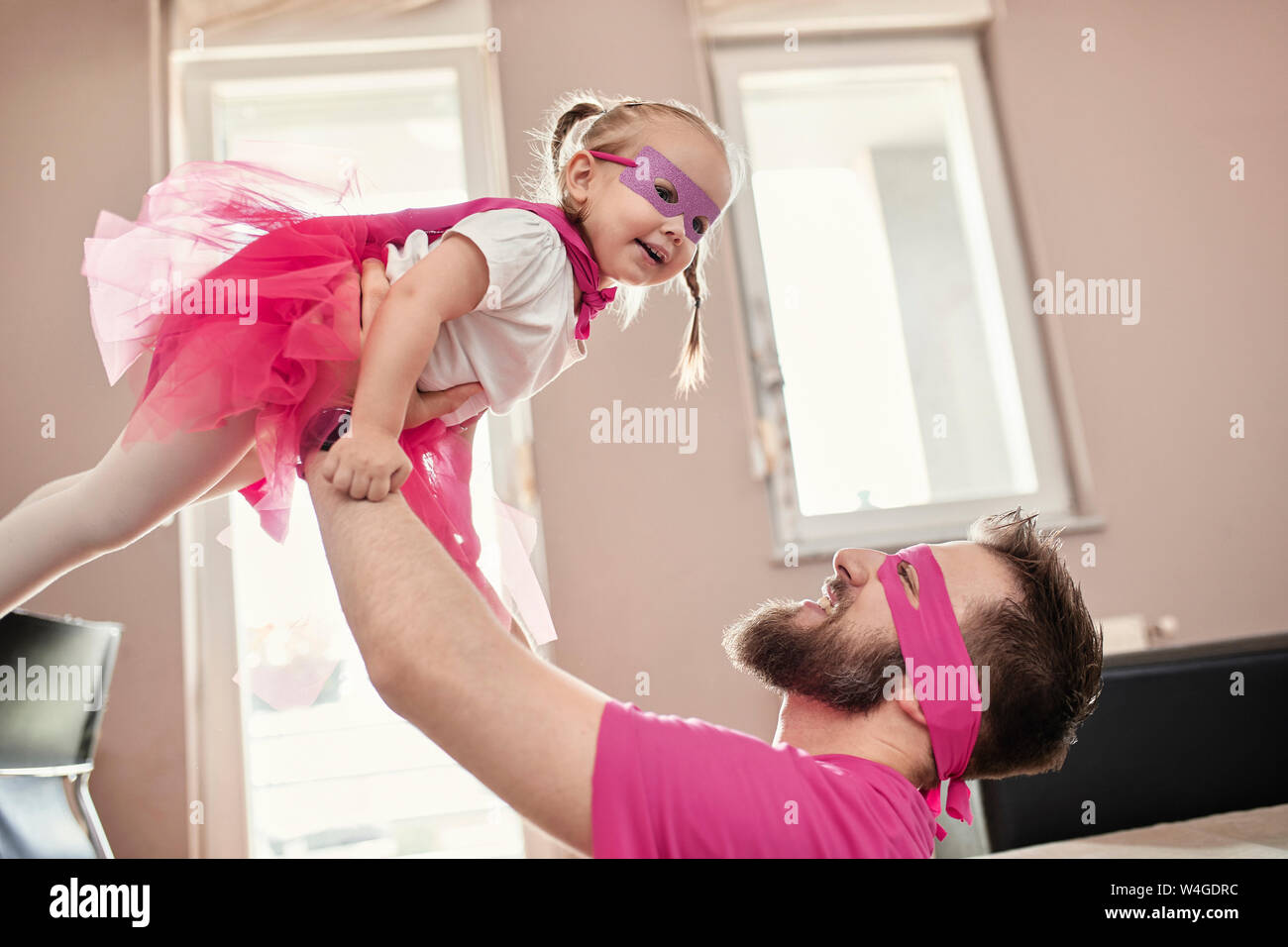 Vater und Tochter spielen Superhelden und superwoman, vortäuschen zu fliegen Stockfoto