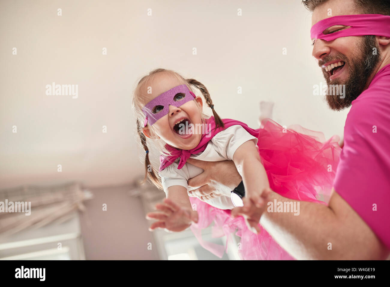 Vater und Tochter spielen Superhelden und superwoman, vortäuschen zu fliegen Stockfoto