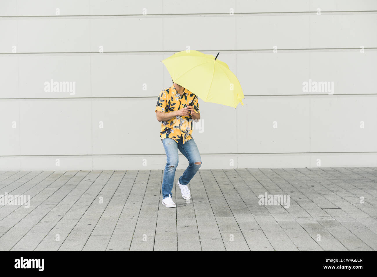Junger Mann mit Aloha Shirt, Yellow Umbrella Stockfoto