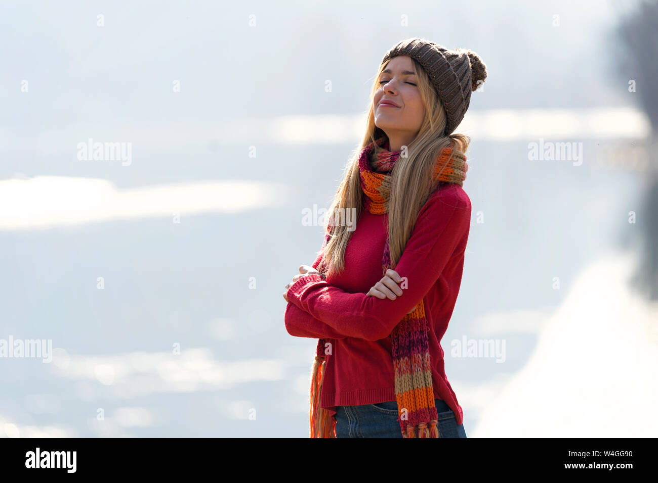 Junge blonde Frau an einem See im Winter Stockfoto