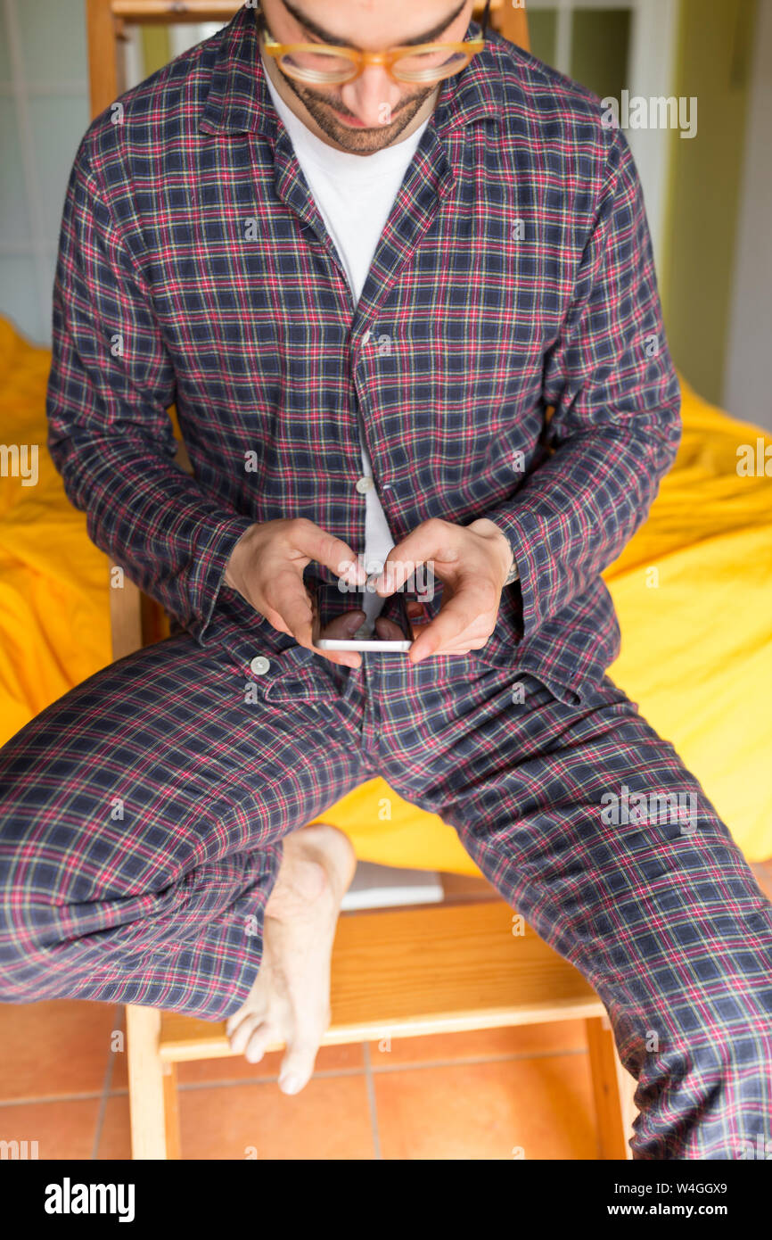 Mann mit Smartphone, sitzen auf holzleiter Stockfoto