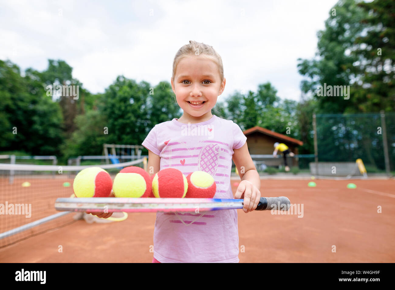 Kleines Mädchen, Lernen, Tennis zu spielen, balancieren Bälle auf einem Schläger Stockfoto