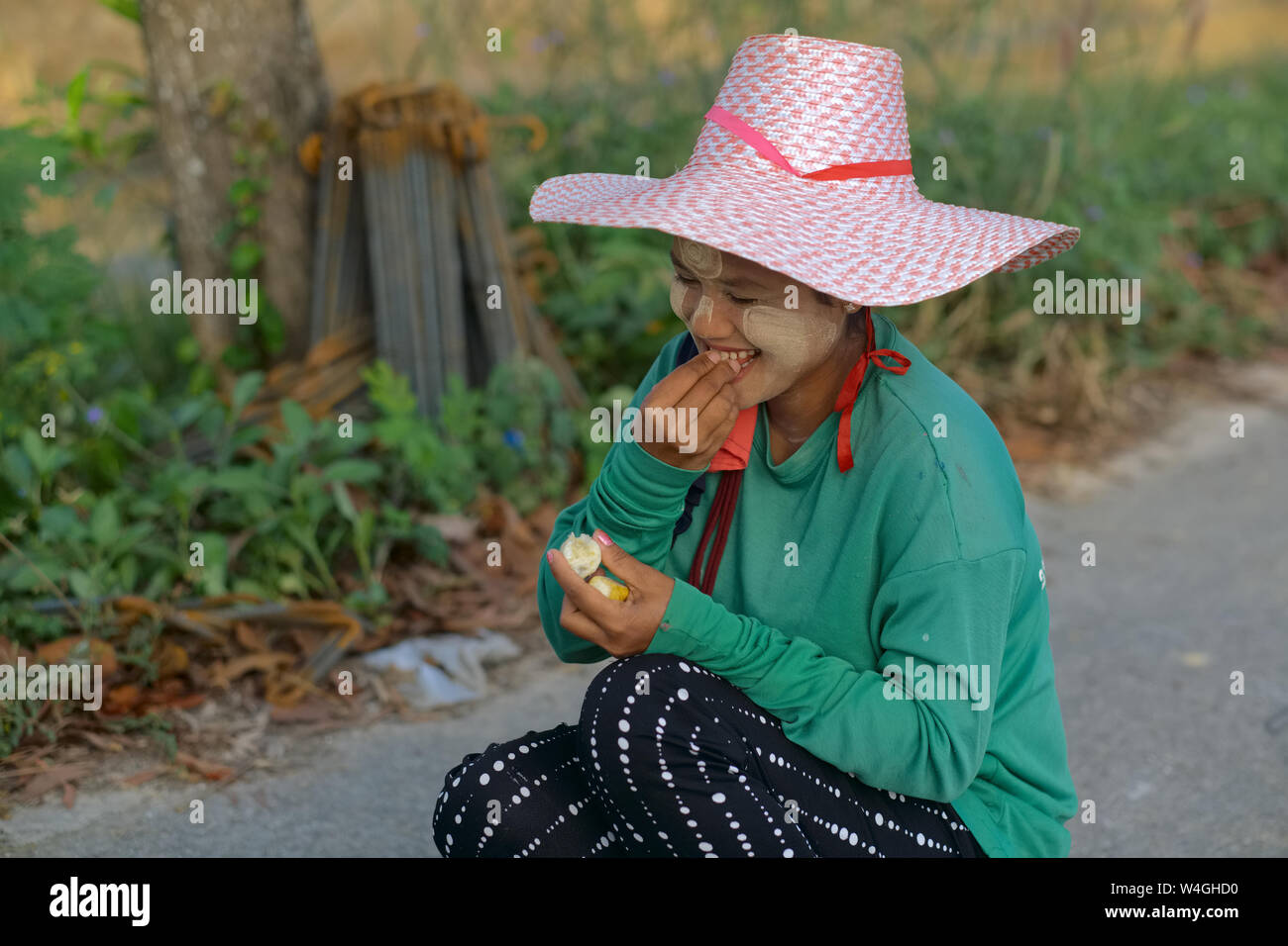 Eine migrantin Mädchen aus Myanmar (Burma), Teil des riesigen Myanmarese Arbeitskräfte in Thailand, schüchtern in einer Mittagspause snack; Ort: Phuket Stockfoto