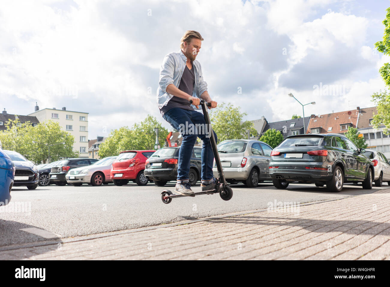 Mann auf E-Scooter, springen in die Luft, Stockfoto