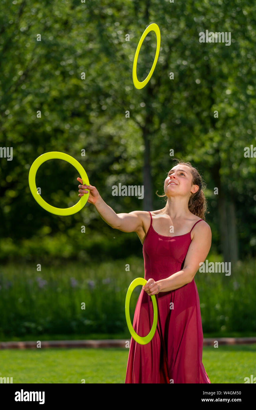 Junge Frau jonglieren mit Ringen Stockfoto
