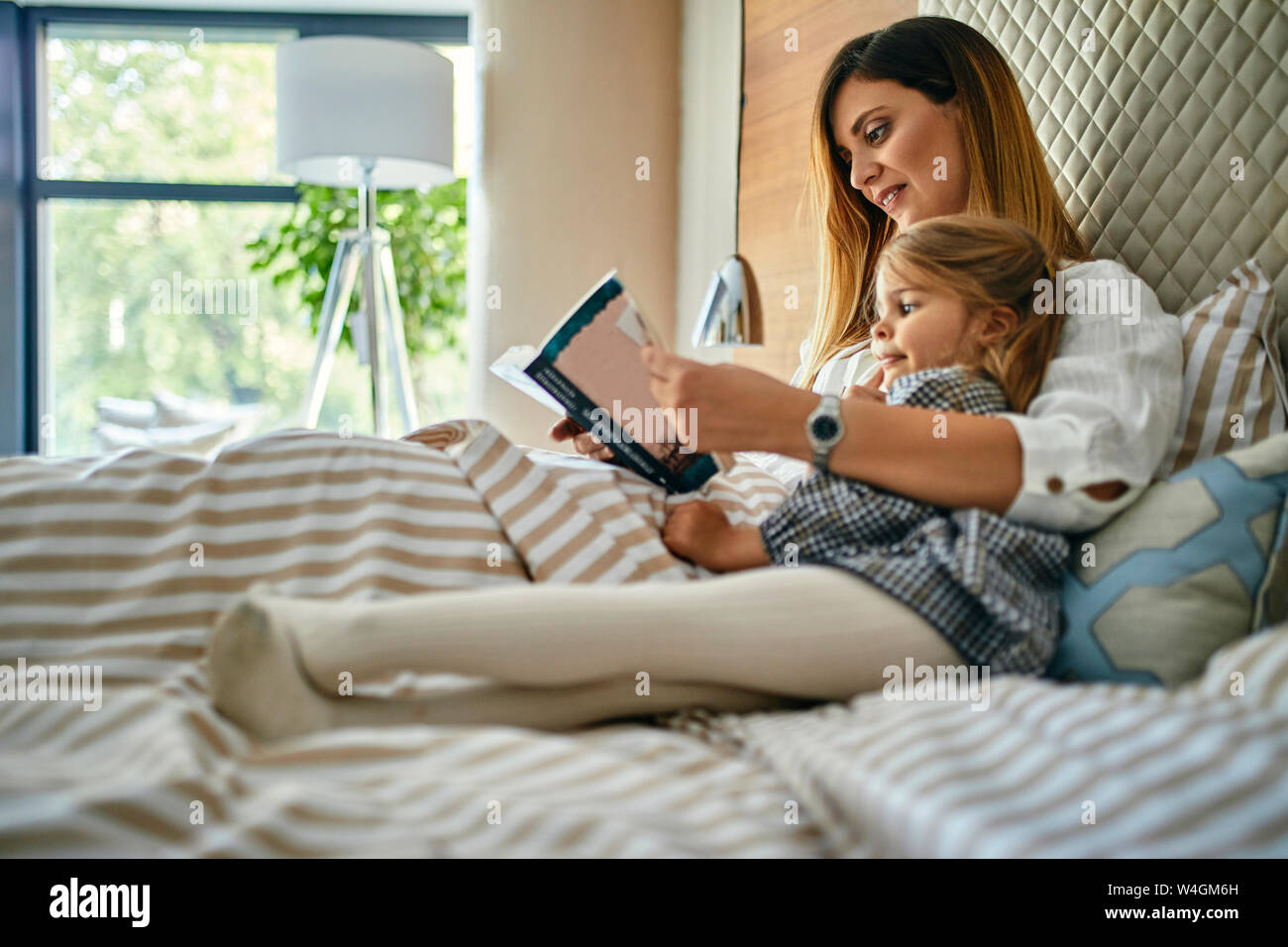 Mutter und daughhter ein Buch lesen im Bett Stockfoto
