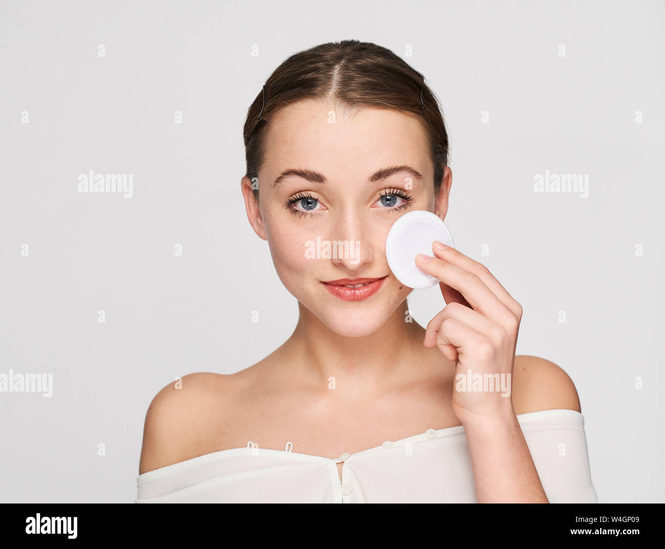 Portrait von lächelnden jungen Frau mit Baumwolle Pad Stockfoto