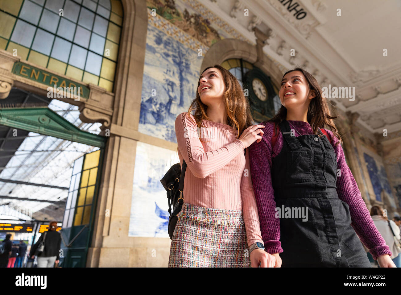 Zwei lächelnde junge Frauen vor der Station Gebäude um, Porto, Portugal Suche ständigen Stockfoto