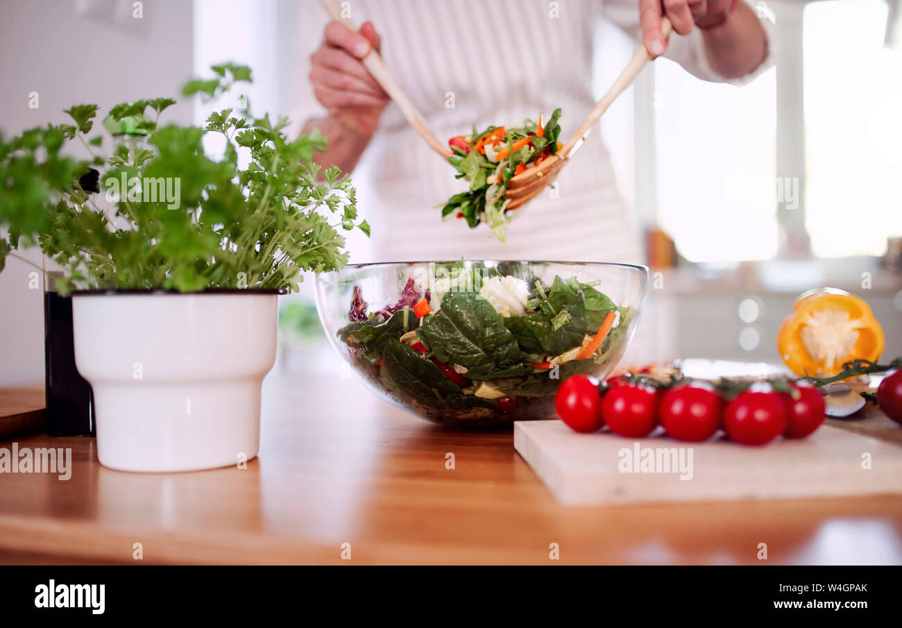 Reife Frau Zubereitung Salat in Ihrer Küche Stockfoto