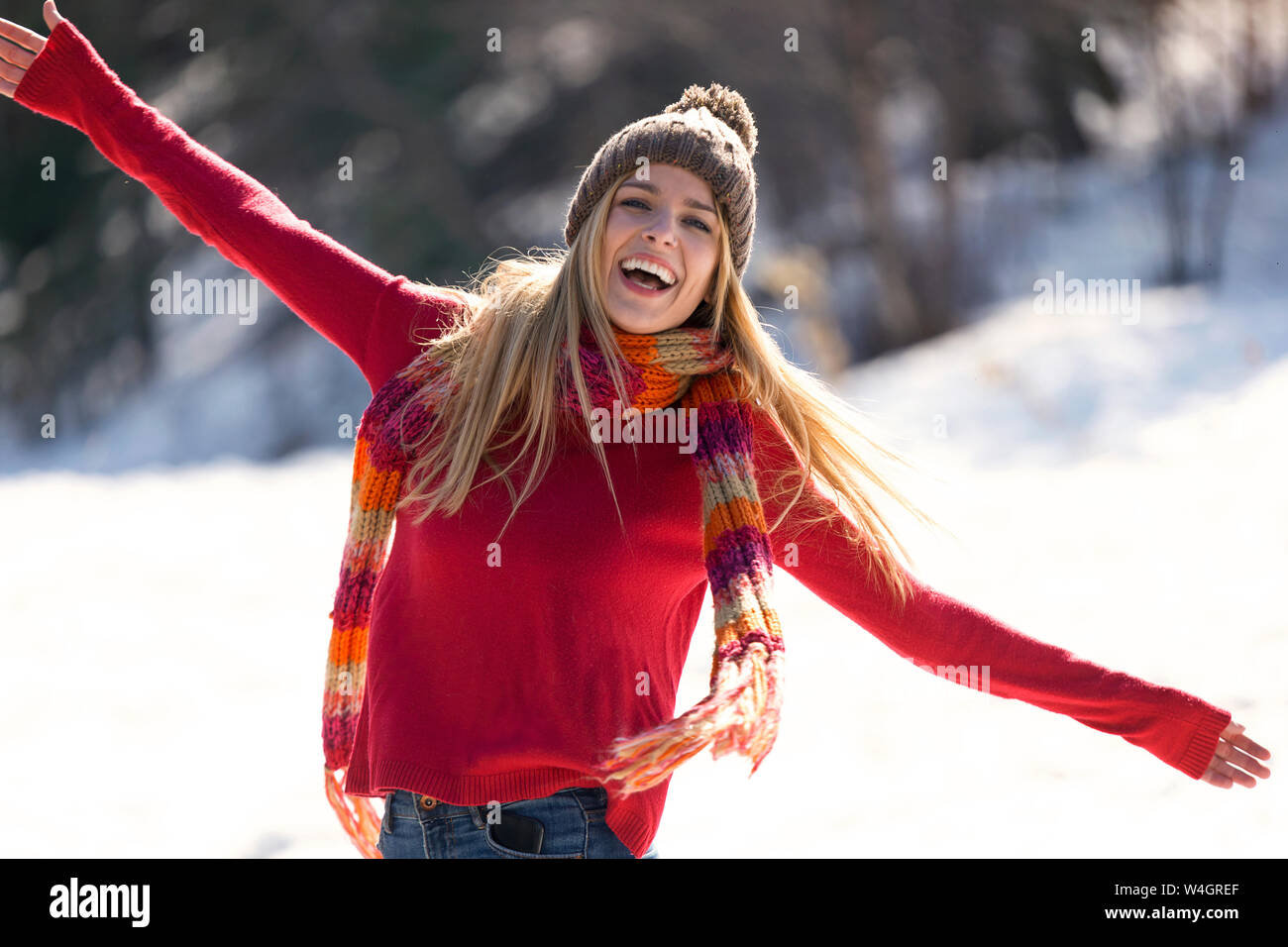 Junge blonde Frau Anheben der Arme im Winter Stockfoto