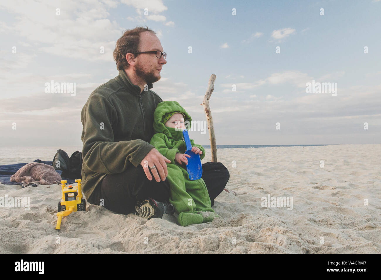 Vater saß mit seiner Tochter an einem Sandstrand, Kurische Nehrung, Litauen Stockfoto