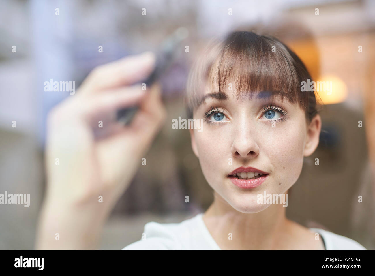Porträt der jungen Geschäftsfrau schreiben auf Glasscheibe Stockfoto