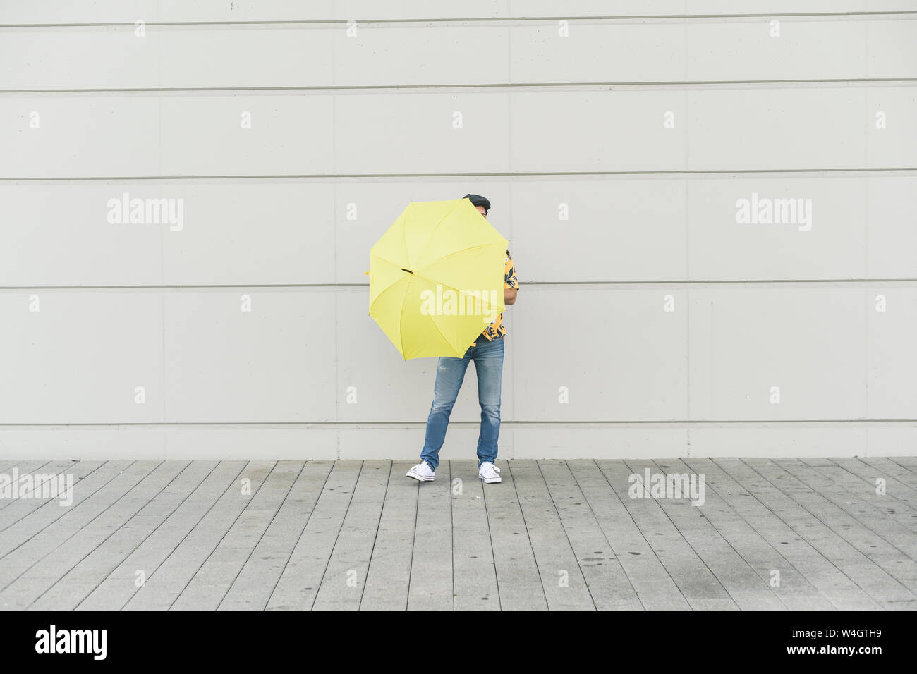 Junger Mann mit Aloha Shirt, Yellow Umbrella Stockfoto