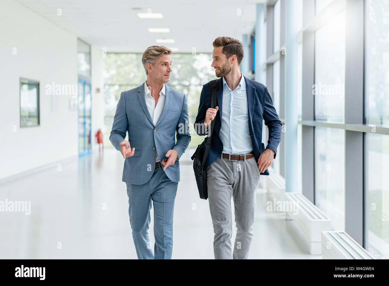 Zwei Geschäftsleute gehen und Sprechen in einem Durchgang Stockfoto