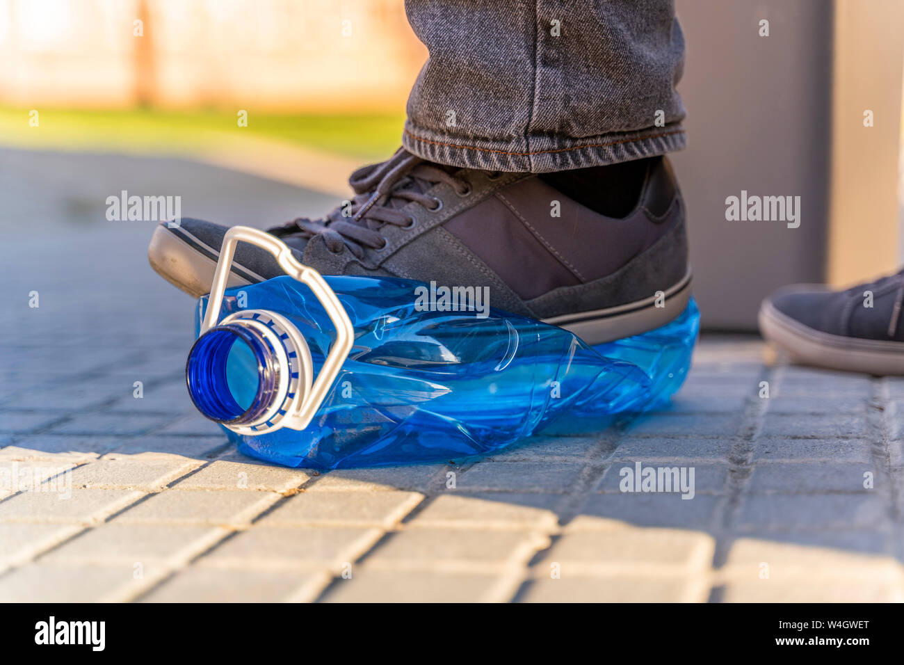 Close-up des man Füße sqashing Plastikflasche für Recycling Stockfoto