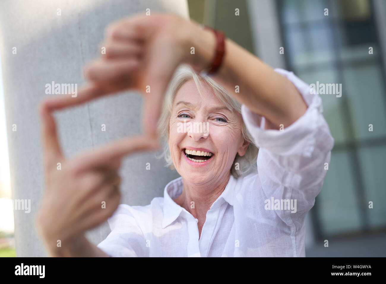 Portrait von Lachen reife Frau Gestaltung Rahmen mit Ihren Fingern Stockfoto