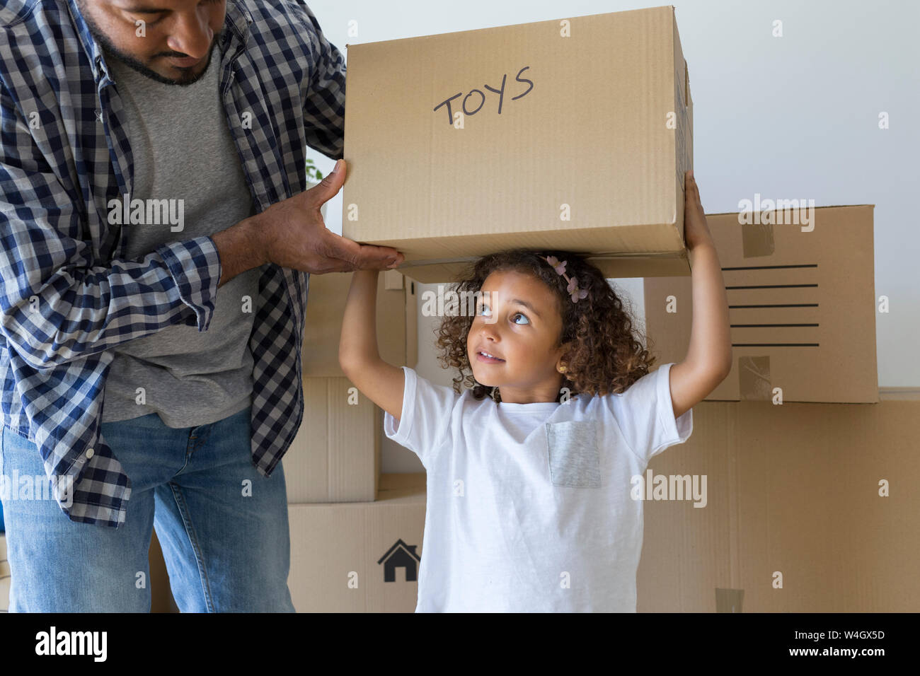 Vater mit Tochter Durchführung Karton im neuen Zuhause Stockfoto