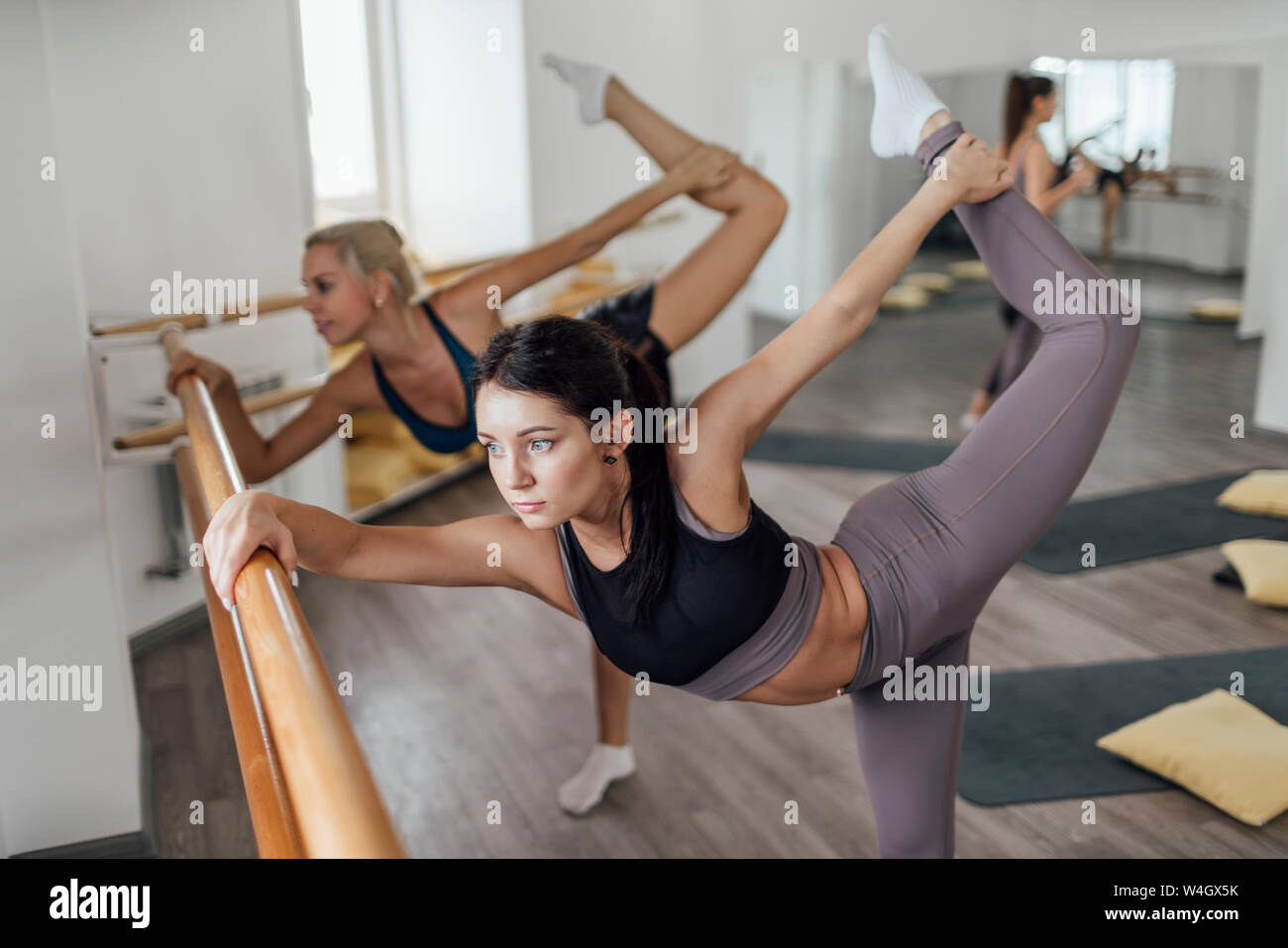 Zwei junge Frauen, Barre Workout im Fitnessraum Stockfoto