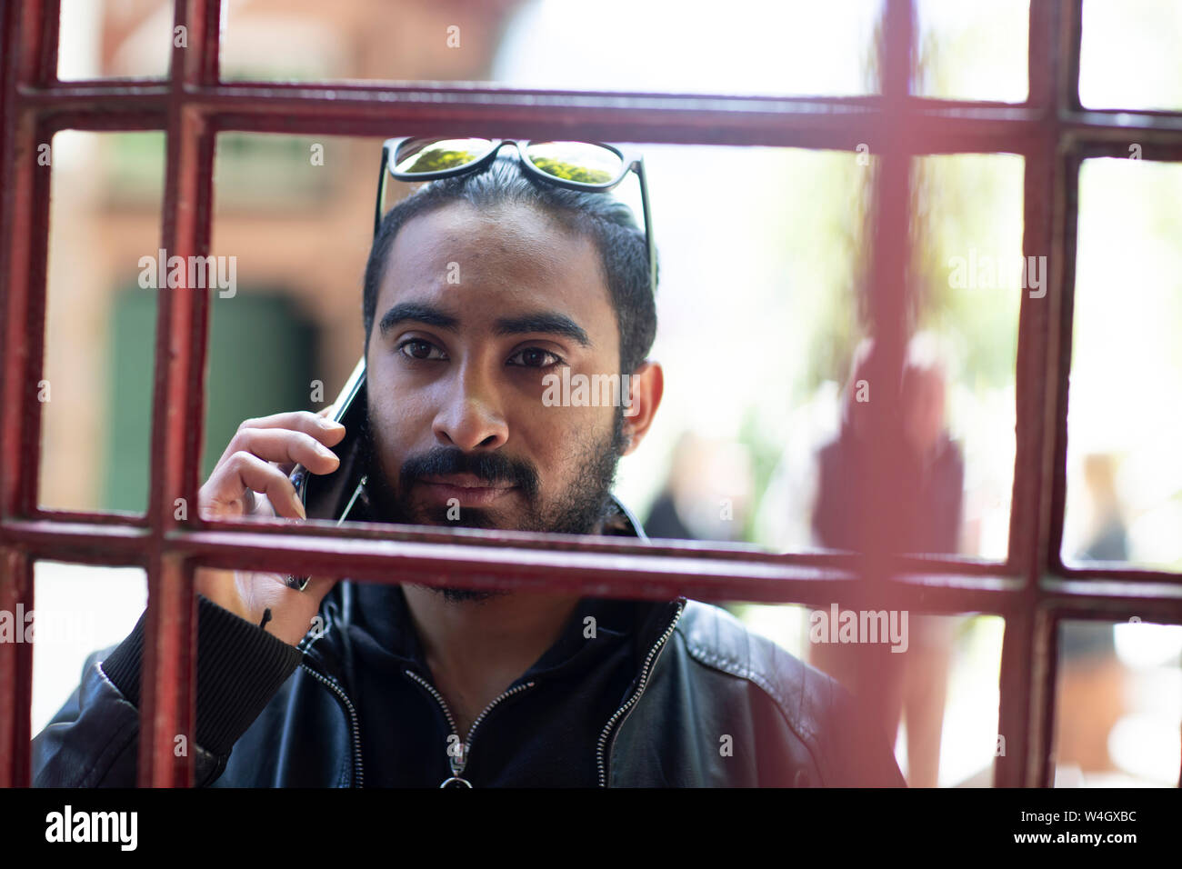 Portrait von bärtiger junger Mann am Telefon Stockfoto