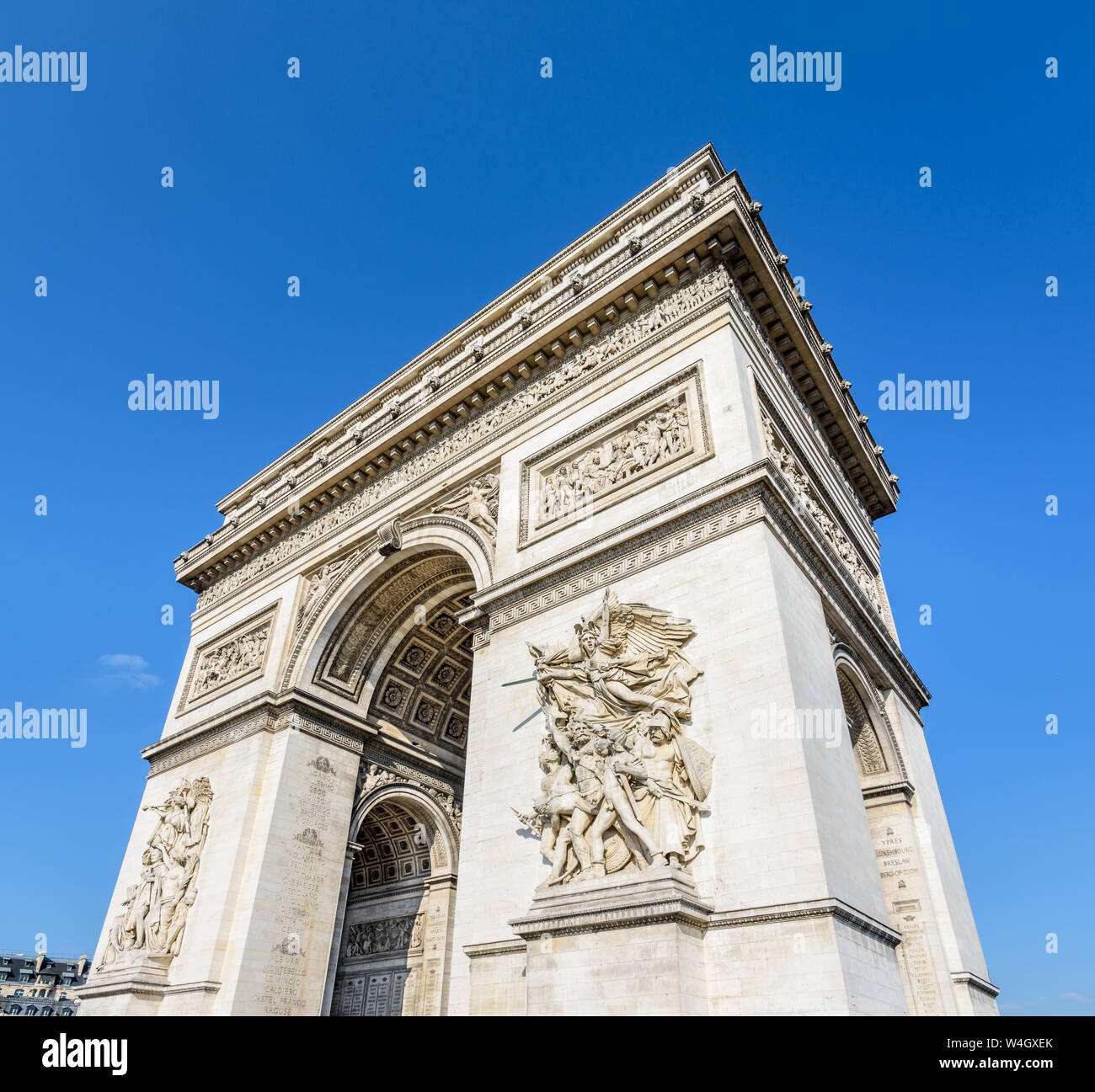 Drei Viertel der östlichen Fassade der Arc de Triomphe in Paris, Frankreich, von der Morgensonne unter einem blauen Himmel beleuchtet. Stockfoto