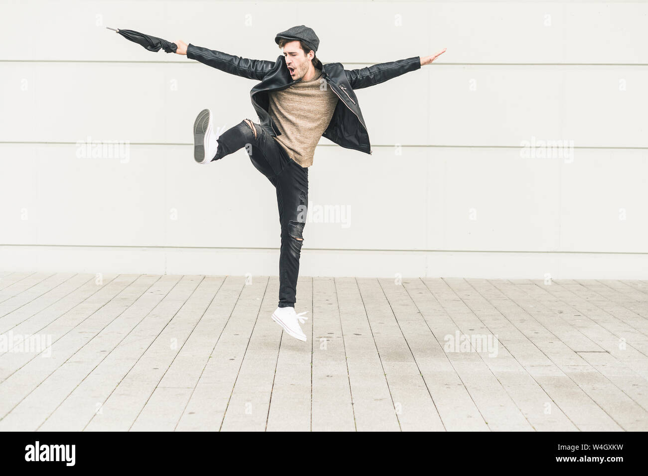 Junger Mann tanzen und springen mit geschlossenem Dach Stockfoto