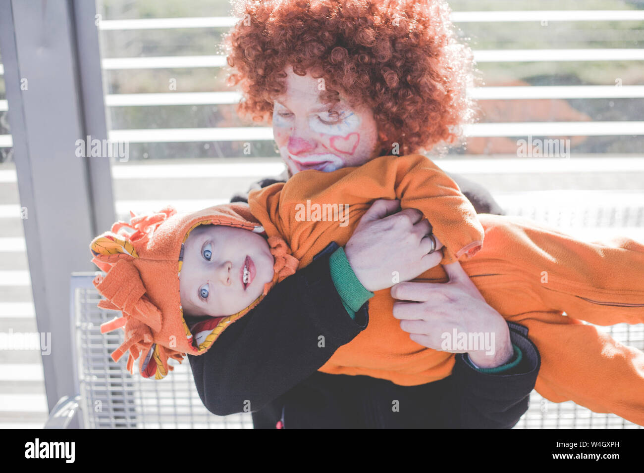 Mann verkleidet sich als Clown und kleinen Jungen als Lion Baby an Karneval verkleidet Stockfoto