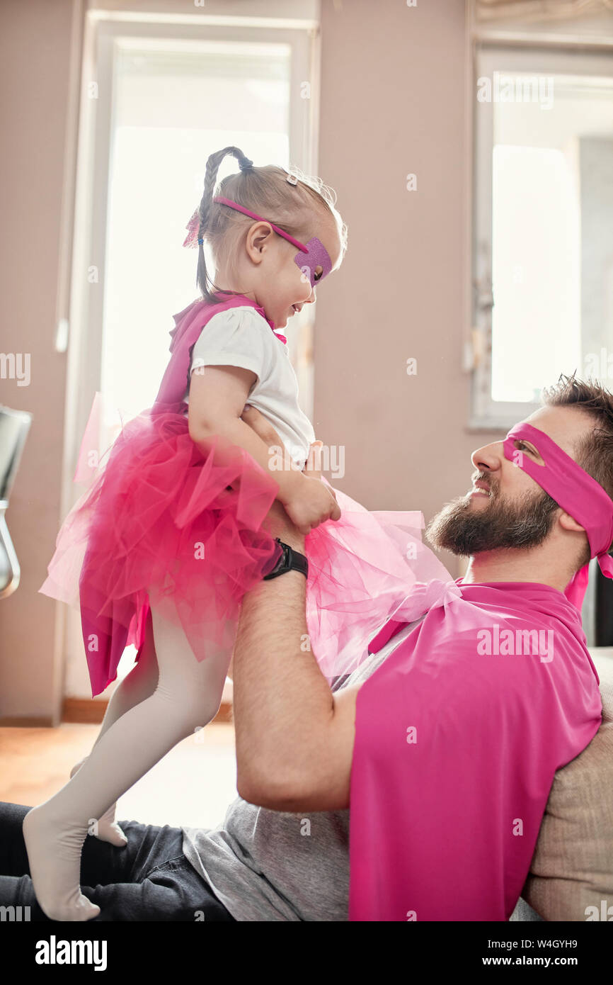 Vater und Tochter spielen Superhelden und superwoman, vortäuschen zu fliegen Stockfoto