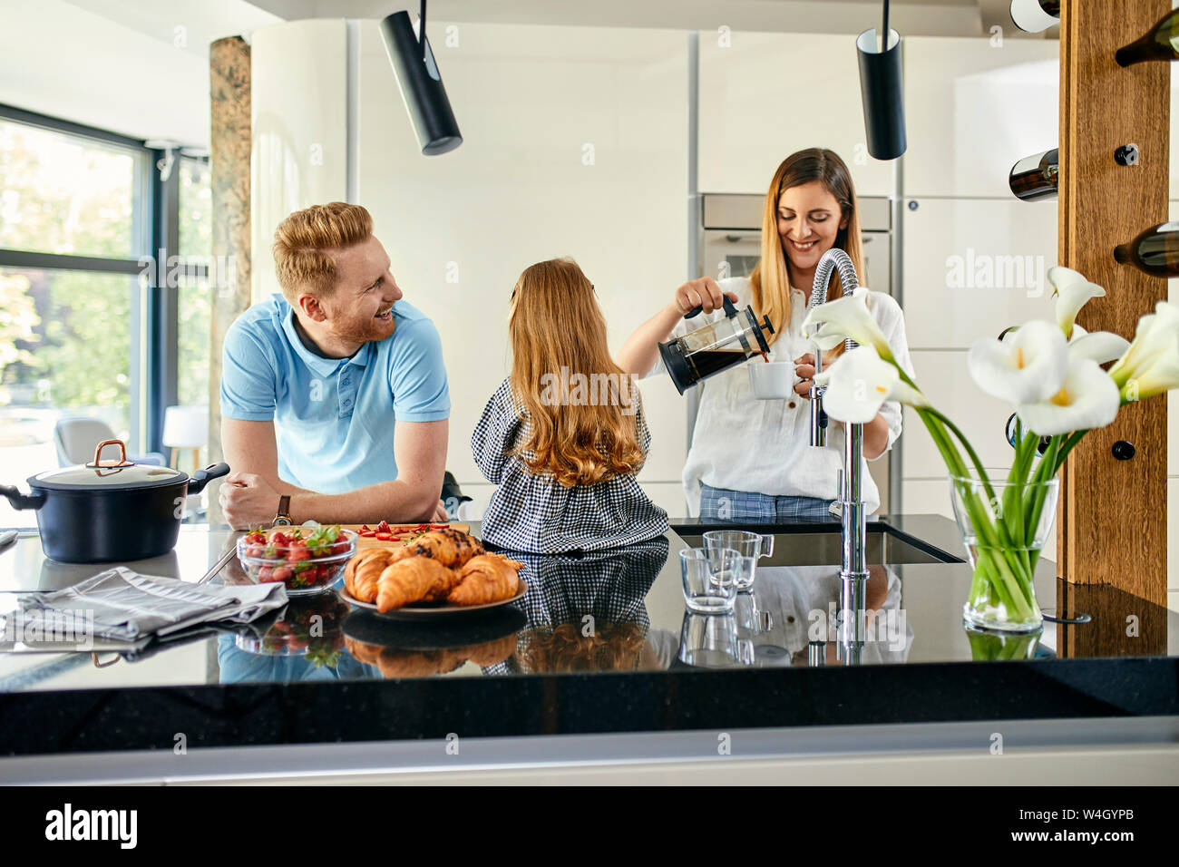 Happy Family essen frische Erdbeeren in der modernen Küche Stockfoto