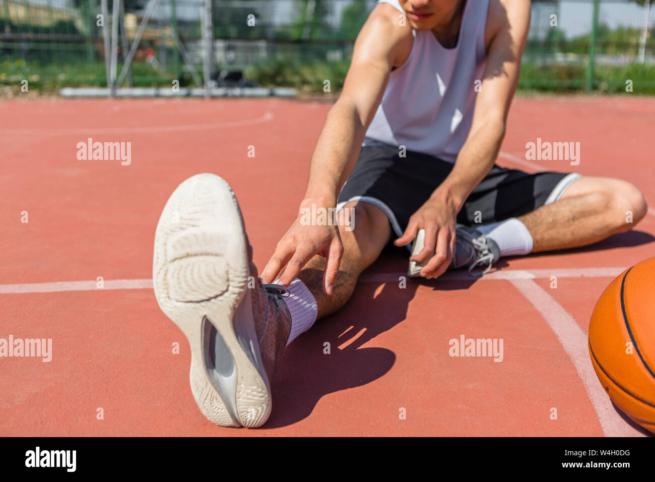 Junge Basketballspieler stretching Bein Stockfoto