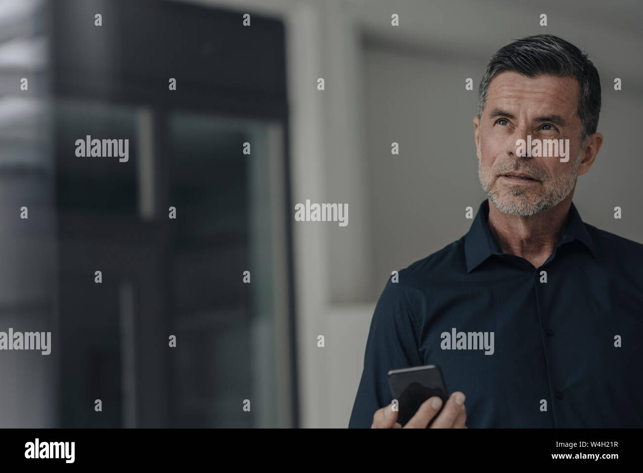 Portrait von schweren Reifen Geschäftsmann mit Mobiltelefon Stockfoto