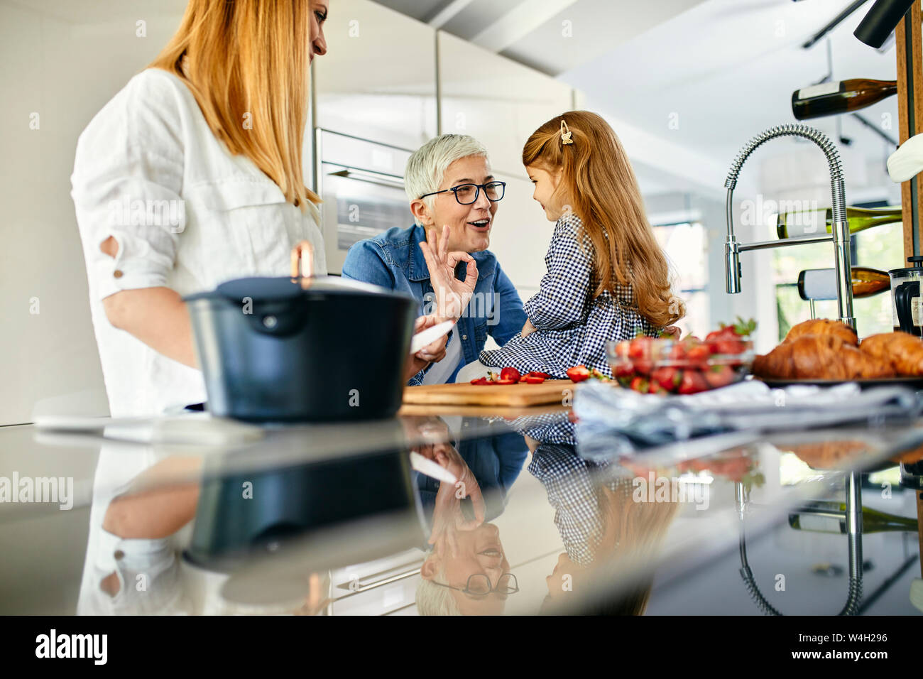 Mutter, Tochter und Großmutter Spaß, hacken Erdbeeren in der Küche Stockfoto