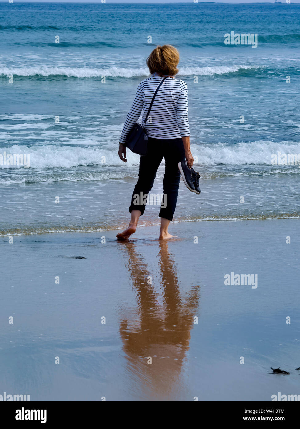 Frau am Strand mit Blick auf Meer Stockfoto