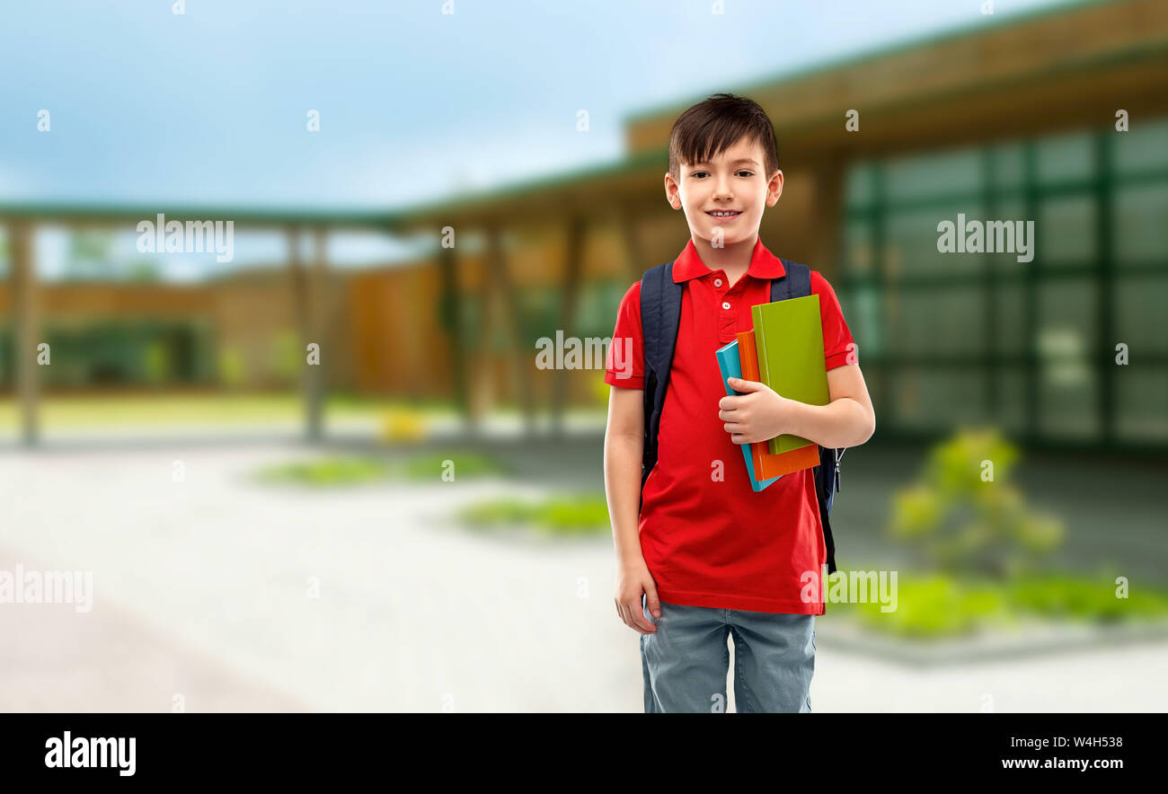 Smiling Student Boy mit Büchern und Schultasche Stockfoto