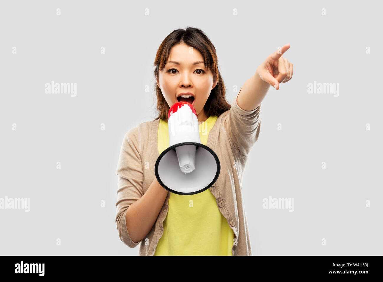 Asiatische Frau sprechen mit Megaphon Stockfoto