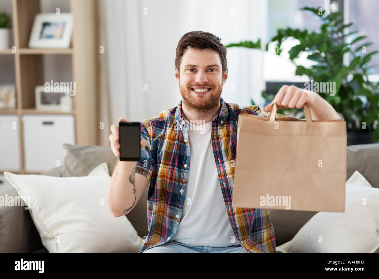 Mann mit Smartphone für Lebensmittel Lieferung Stockfoto