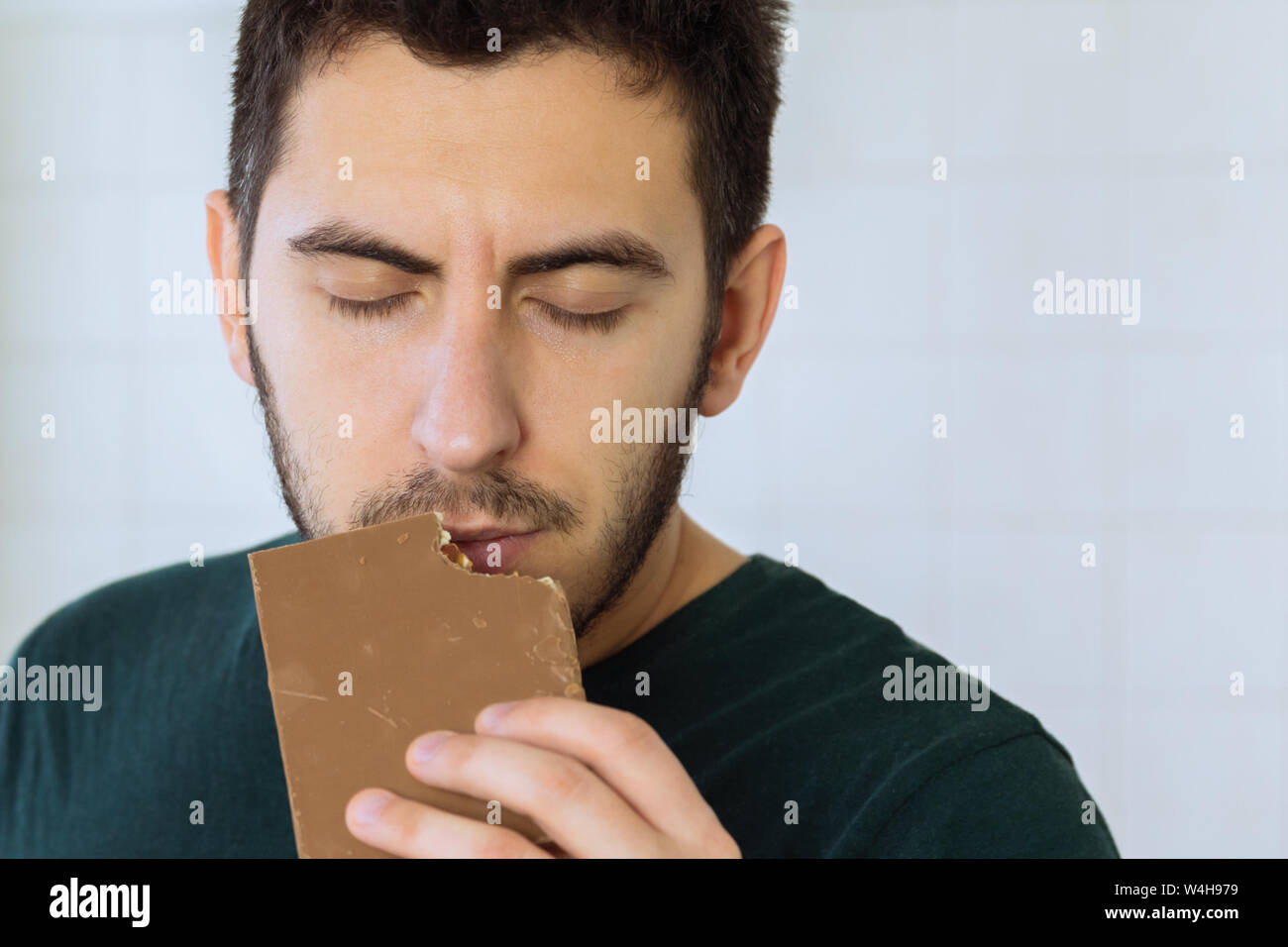 Der Mensch isst Schokolade mit großer Freude. Stockfoto