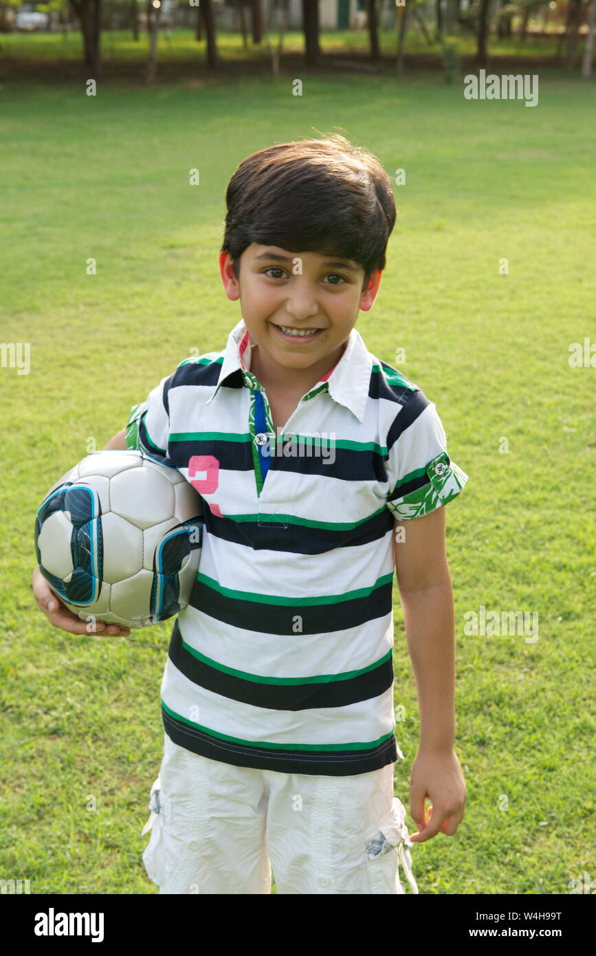 Bildnis eines Knaben halten einen Fußball und lächelnd Stockfoto