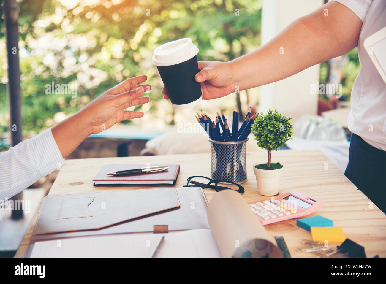 Die Frau, die die Mitarbeiter Partner Team Meeting mit einer Tasse Kaffee. Stockfoto