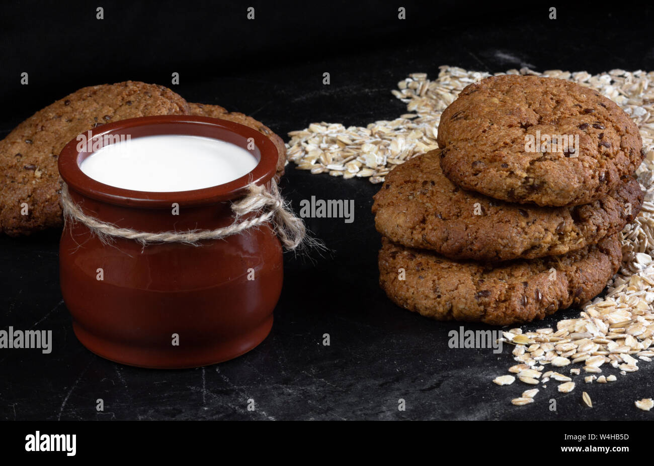 Hausgemachte gebackene oatmeal Cookies mit Bettwäsche Samen auf schwarzen Hintergrund Stockfoto
