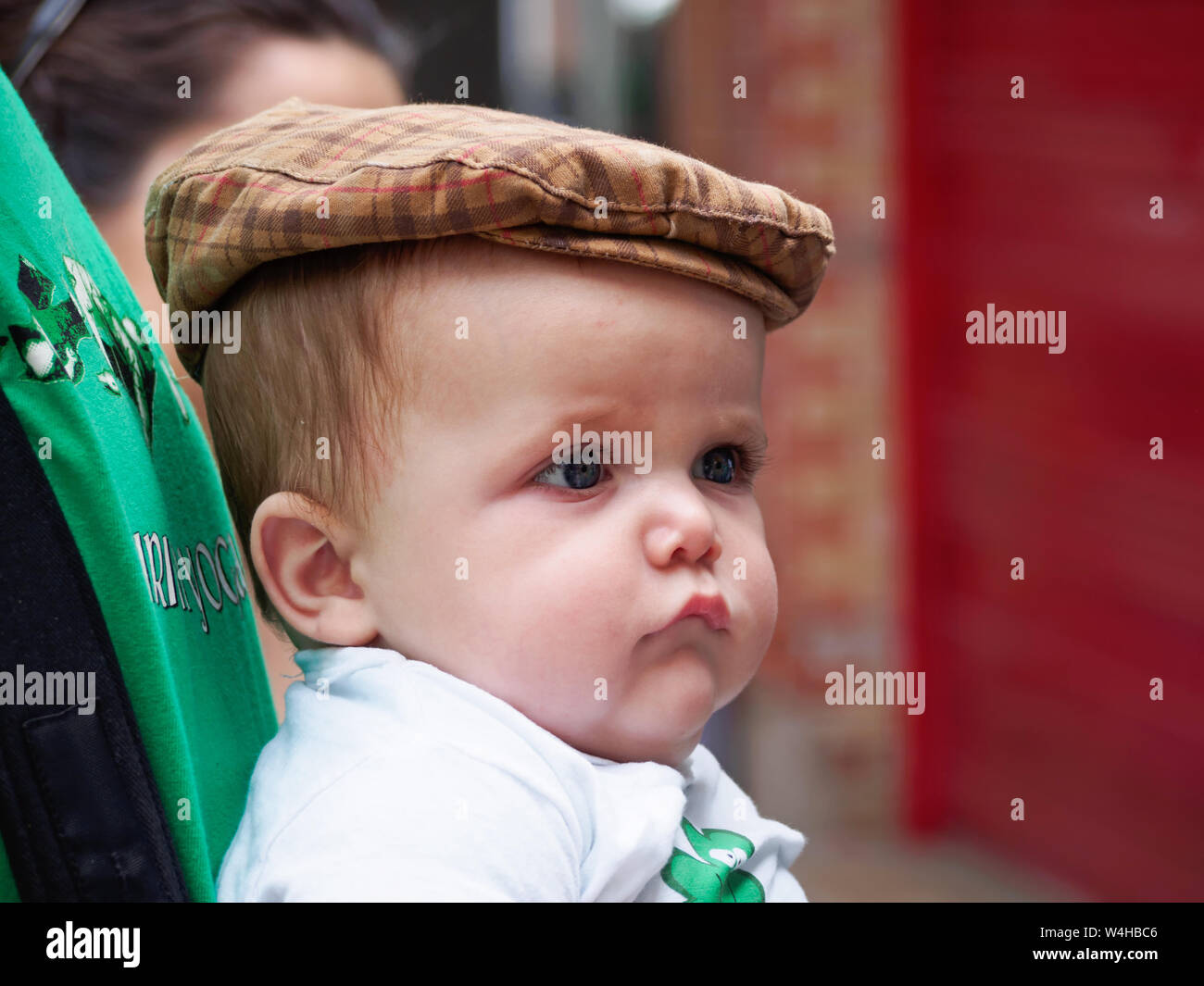 Ein niedliches Baby Boy mit chubby Wangen trägt einen Flachbild Tweed Cap. 2016 Saint Patrick's Day Block Party in Corpus Christi, Texas USA. Stockfoto