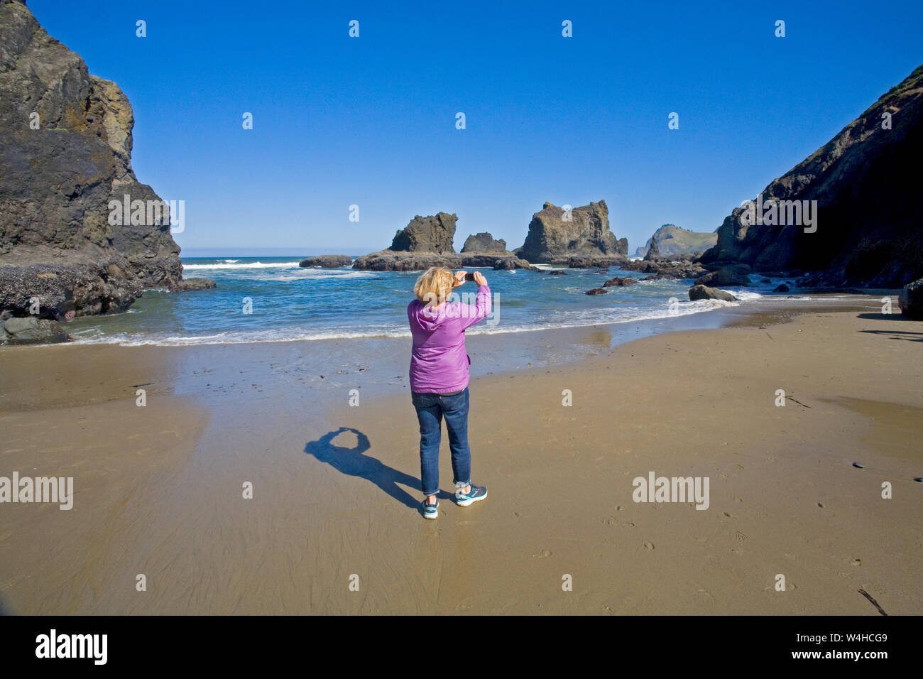 Eine teourist nimmt ein Foto auf den Pazifischen Ozean mit Ihrem Iphone in der Nähe von Lincoln City, Oregon, auf der Oregon Pazifikküste. Stockfoto