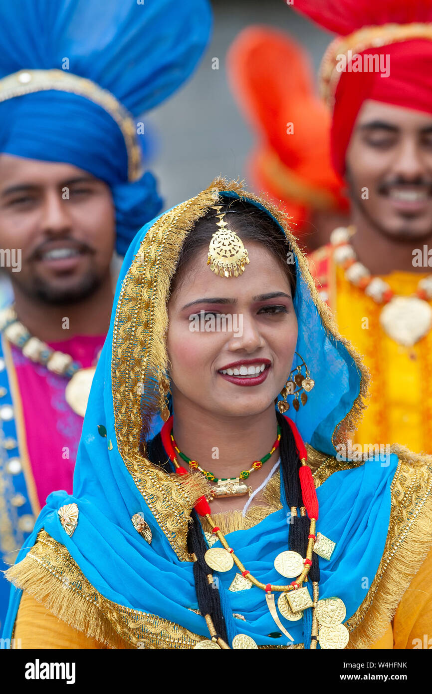Lächelnd indische Frau das Tragen der traditionellen indischen nationalen Kleid. Zwei lächelnde Männer hinter Stockfoto