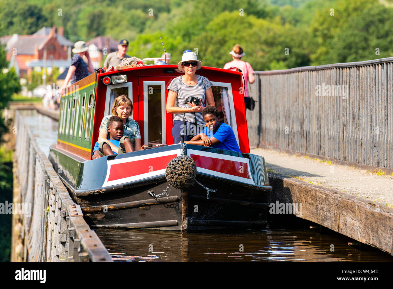 Leute auf einem Kanal Boot überfahrt Pontcysyllte Aquädukt, Wales, UK. Kinder genießen eine schmale Bootsfahrt auf einem sonnigen Sommertag. Stockfoto
