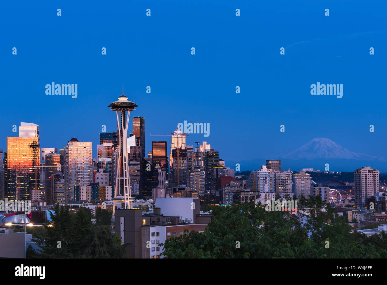Die Seattle Skyline von Kerry Park mit Reflexionen der orange und rosa Sonnenuntergang im Glas des Wolkenkratzer mit Mount Rainier in der Ferne Stockfoto