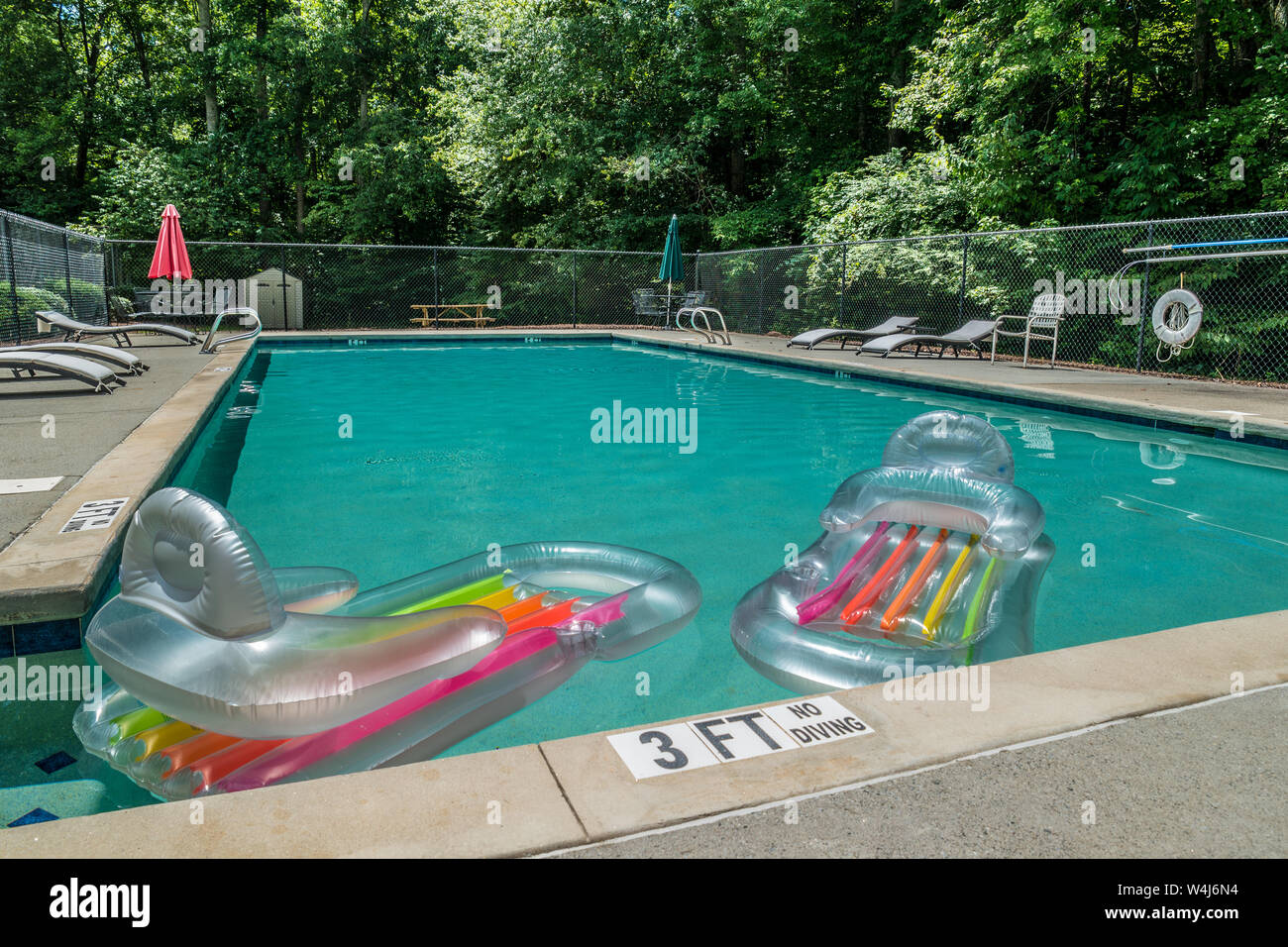 Zwei aufblasbare schwebt in den Pool an einem heißen sonnigen Nachmittag im Sommer mit niemand im Wasser Stockfoto