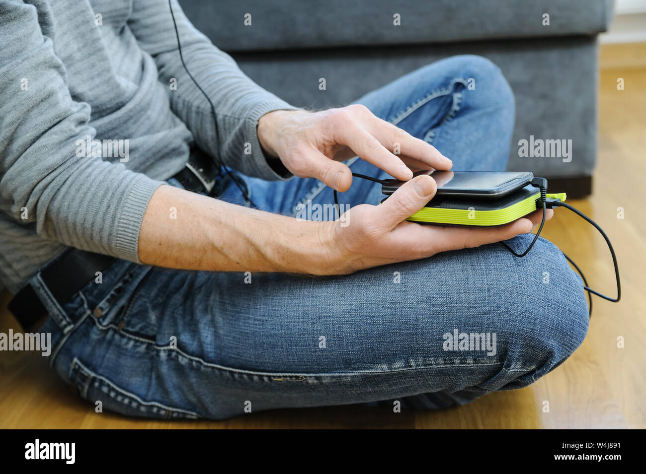 Ein Mann hält ein Smartphone und eine Bank. Stockfoto