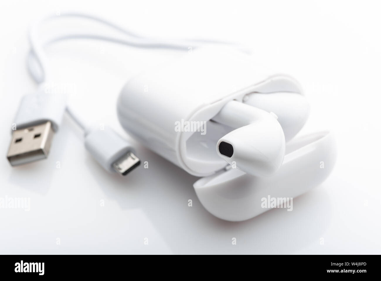 Drahtlose weiße Kopfhörer in das Feld ein. Es ist ein Ladekabel. Stockfoto